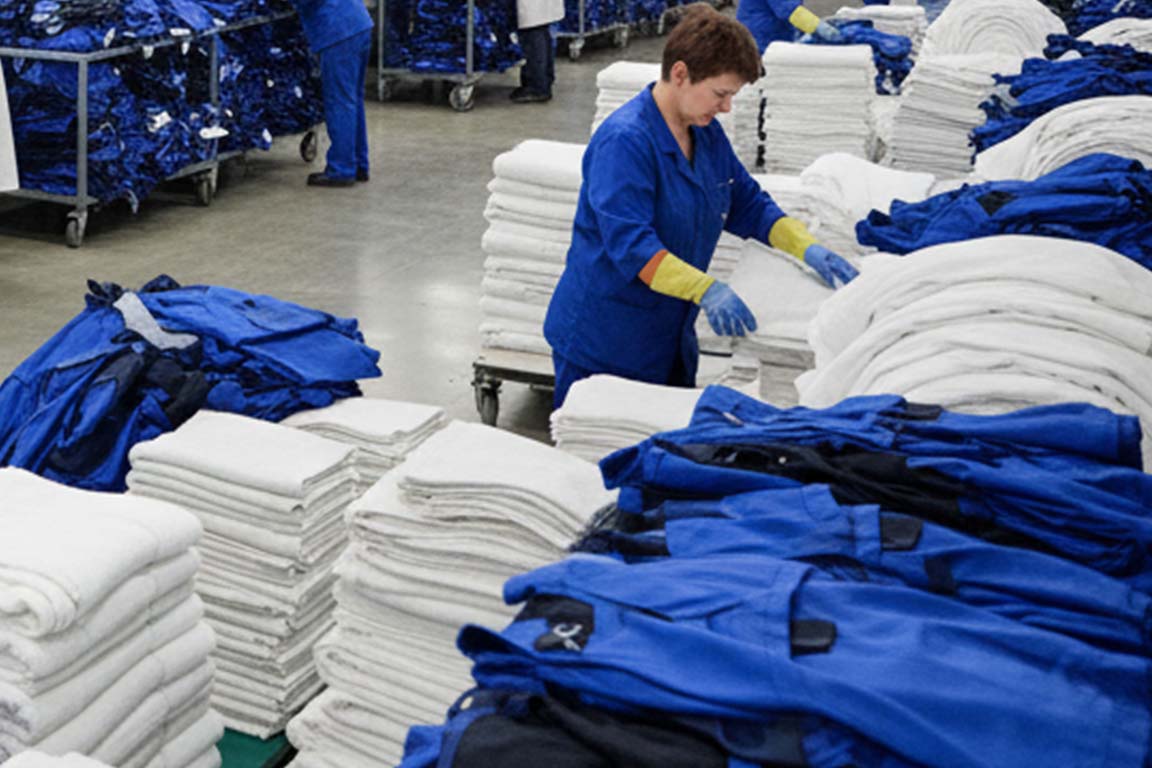 Mitarbeiter bei der professionellen Textilpflege in der Großwäscherei Lübeck